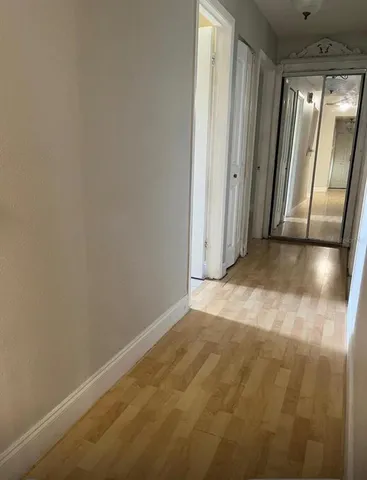 an empty room with wooden floor and mirror