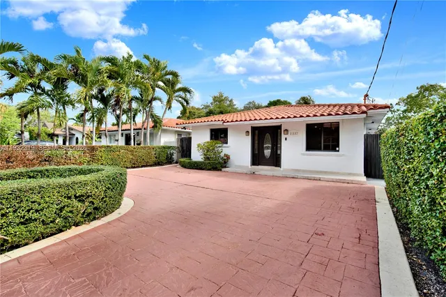 a front view of a house with a garden
