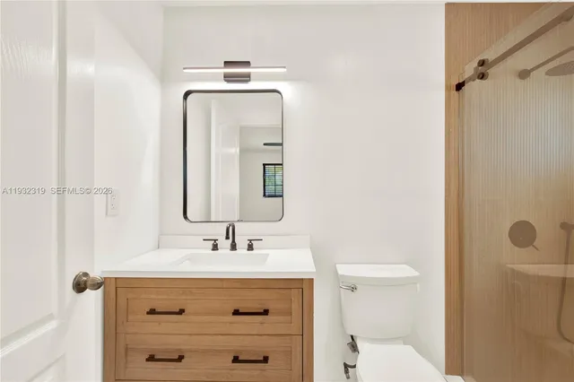 a bathroom with a sink a toilet and shower