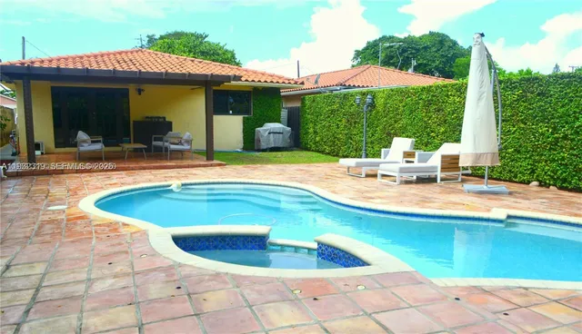 a view of a house with swimming pool and sitting area
