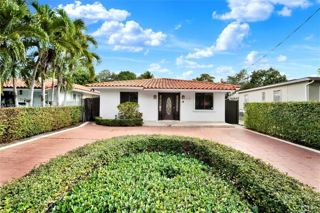 a front view of a house with a garden