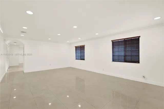 an empty room with a kitchen and a window