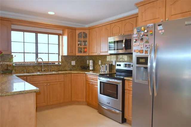 a kitchen with stainless steel appliances granite countertop a refrigerator and a sink