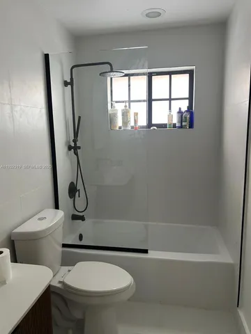 a white toilet sitting next to a bath tub shower