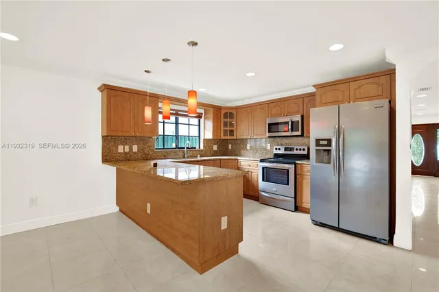 a kitchen with stainless steel appliances granite countertop a refrigerator and a stove