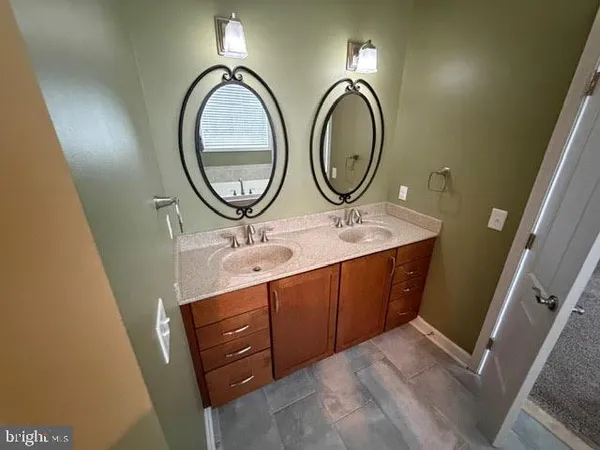 a bathroom with a double vanity sink and a mirror