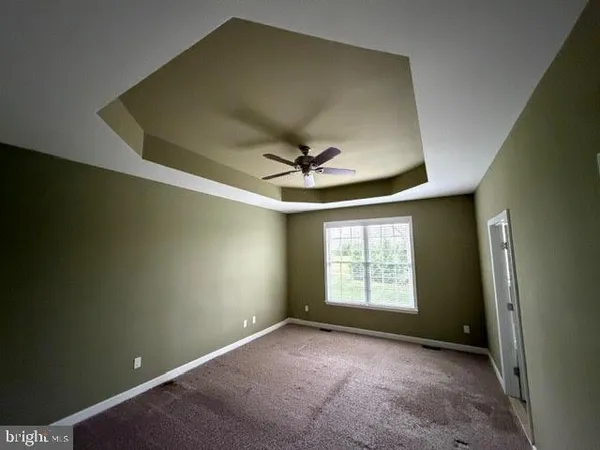 an empty room with a ceiling fan and window