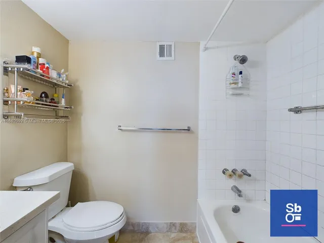 a white toilet sitting next to a bath tub