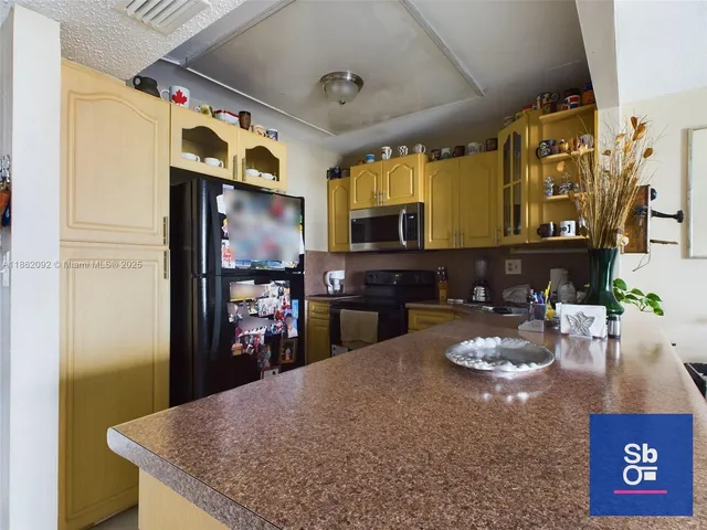 a kitchen with stainless steel appliances granite countertop a sink refrigerator and cabinets