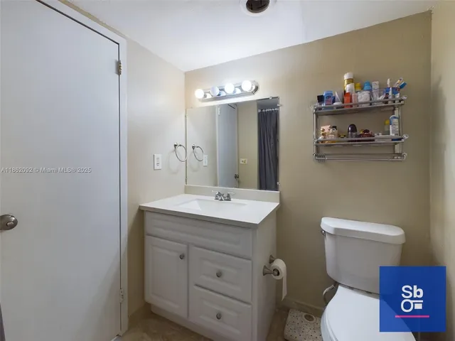 a bathroom with a toilet a sink and mirror