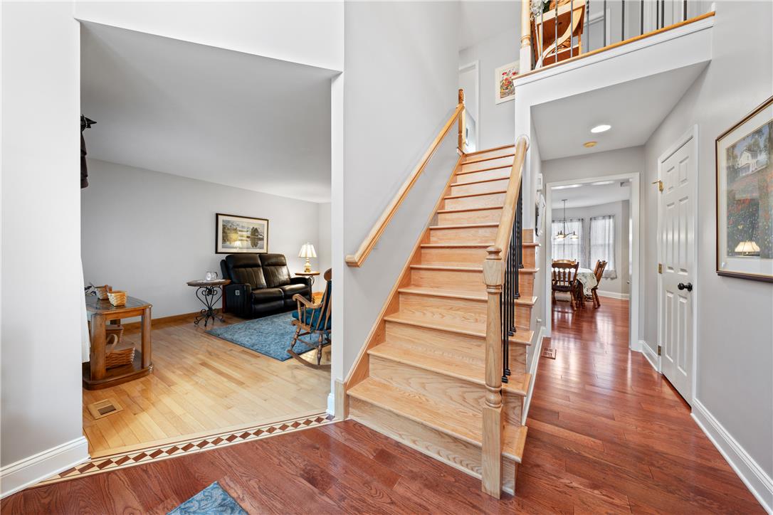 4568 Greenfield Road Bethlehem, PA 18017 - Photo 3 of 59 A grand staircase with rich hardwood flooring welcomes guests into a bright, inviting home.