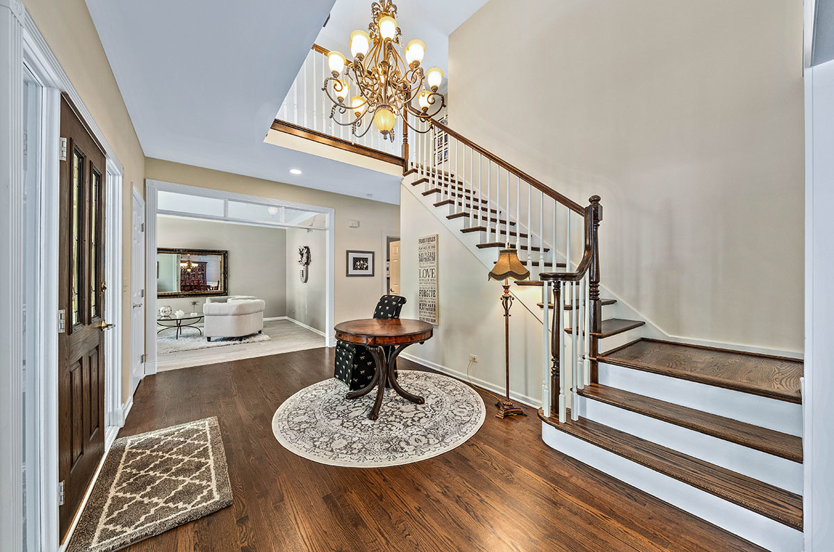 4435 Esquire Circle Naperville, IL 60564 - Photo 2 of 45 a dining room with wooden floor a chandelier a wooden table and chairs
