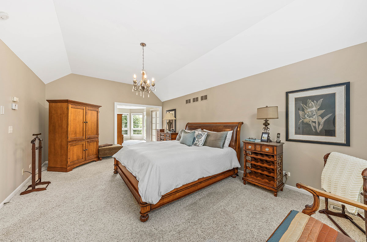 4435 Esquire Circle Naperville, IL 60564 - Photo 17 of 45 a spacious bedroom with a bed a dresser and large windows