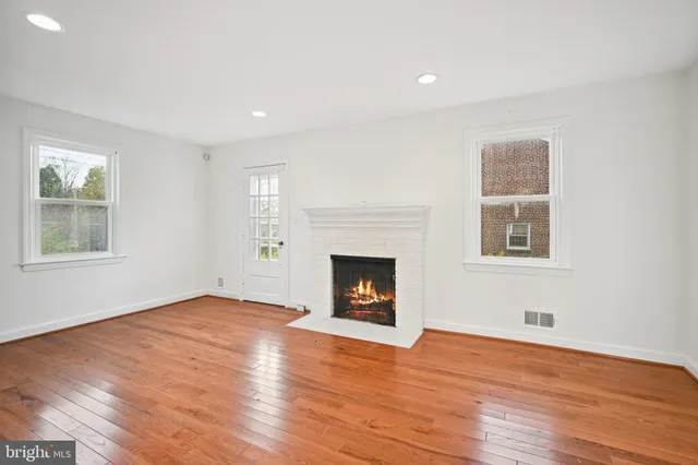 a view of an empty room with window and fire place