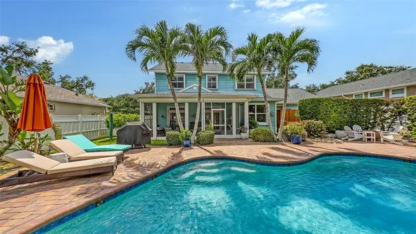 a view of a house with backyard sitting area and swimming pool