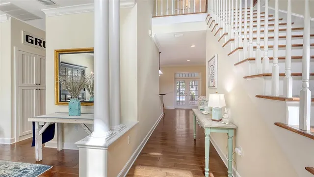 a hallway with a dining table wooden floor and a large window