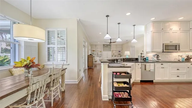 a large white kitchen with lots of counter space a sink appliances and cabinets