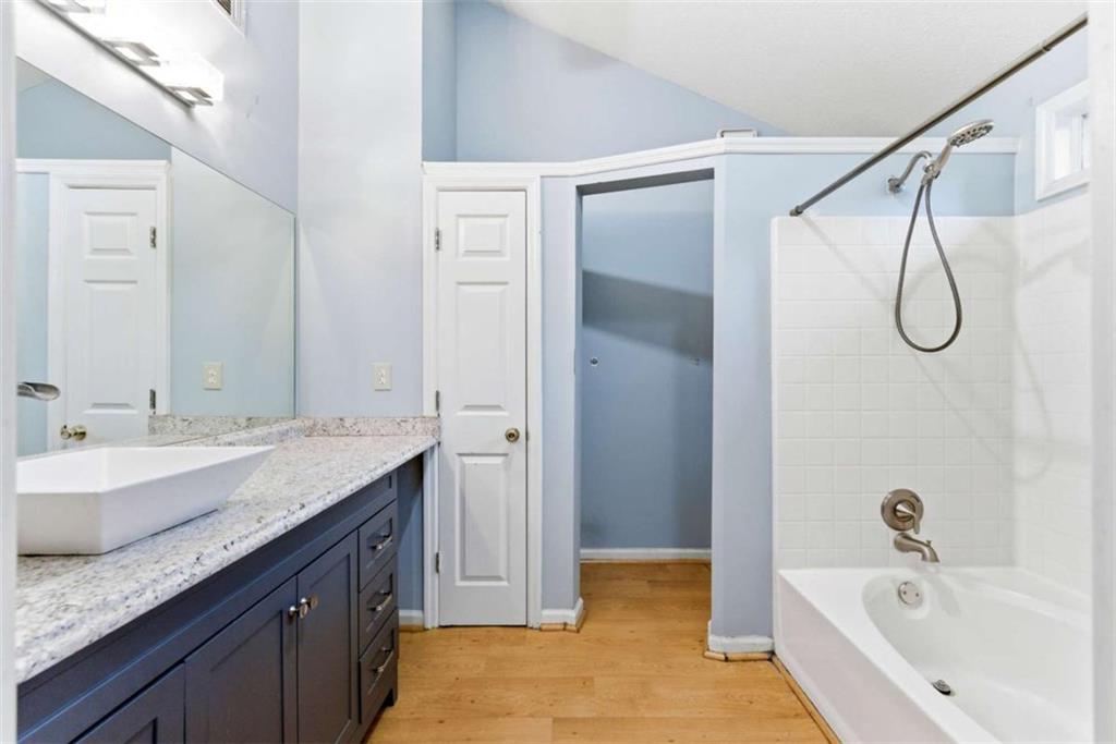 6581 Coventry Point Austell, GA 30168 - Photo 16 of 20 a bathroom with a granite countertop sink a mirror and a bathtub
