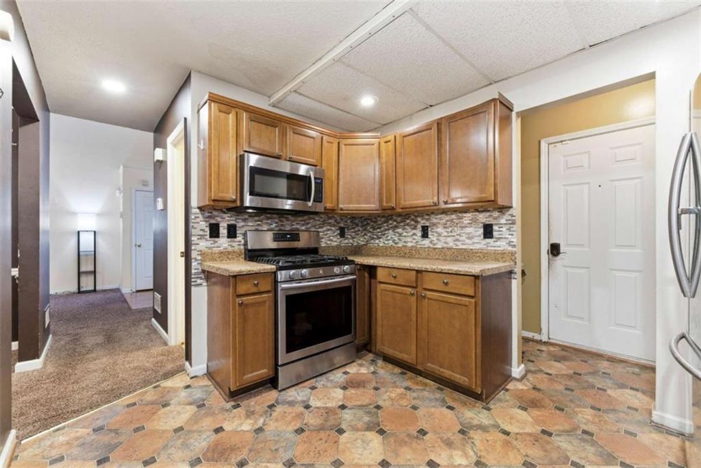 6581 Coventry Point Austell, GA 30168 - Photo 9 of 20 a kitchen with stainless steel appliances granite countertop a stove a sink and a refrigerator