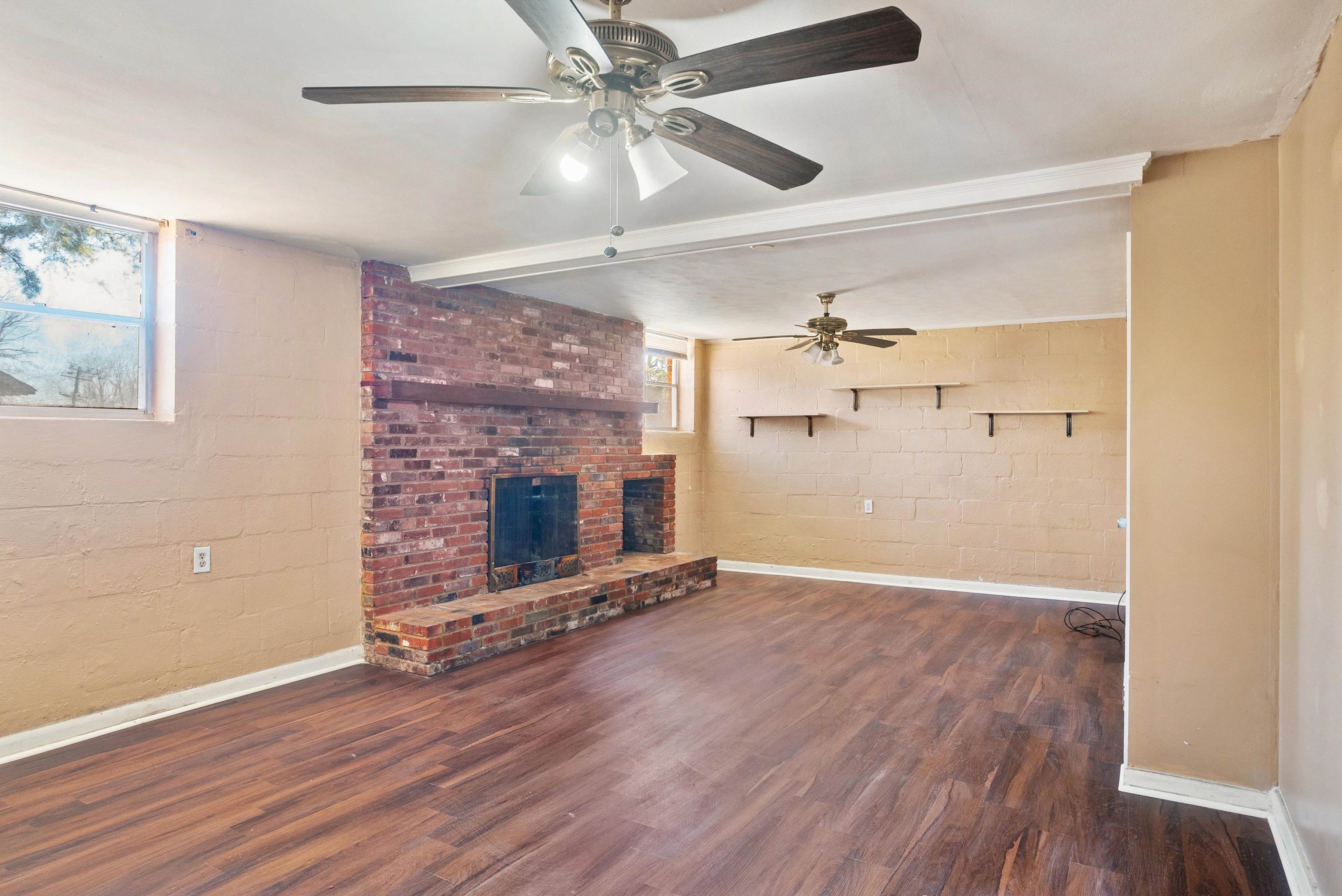 4696 Stage Road Memphis, TN 38128 - Photo 17 of 23 a view of a livingroom with wooden floor a ceiling fan a fireplace and windows