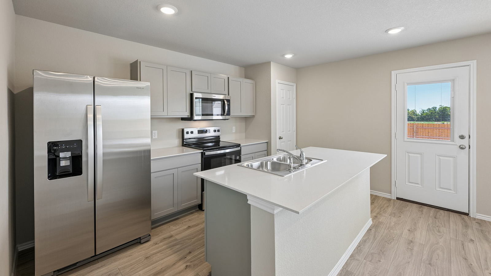 Gleaming stone counters and warm wood floors define this modern, functional kitchen design.
