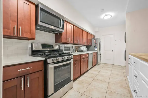 a kitchen with stainless steel appliances granite countertop a stove a sink and a microwave