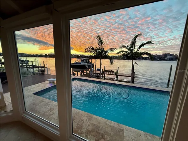 a living room with furniture kitchen view and a large window