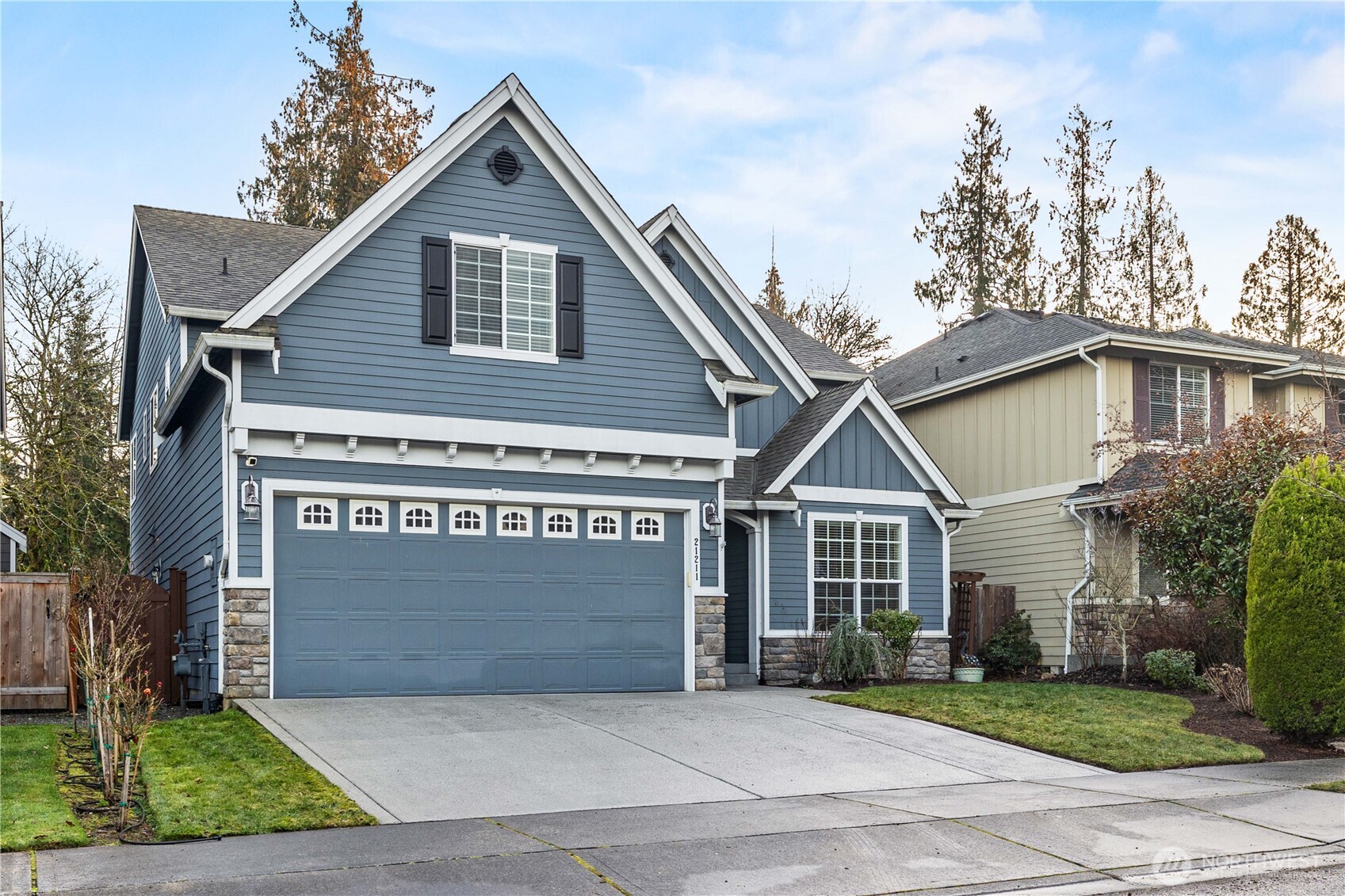21211 Southeast 260th Street Maple Valley, WA 98038 - Photo 2 of 40 a front view of a house with a yard and garage