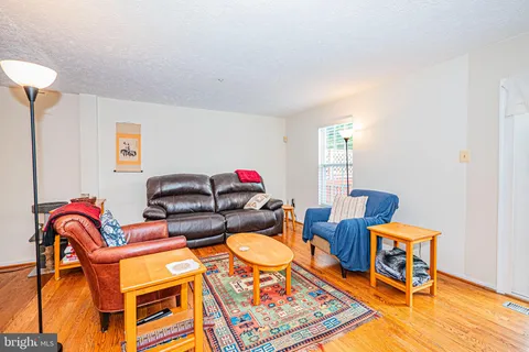 a living room with furniture a rug and a lamp
