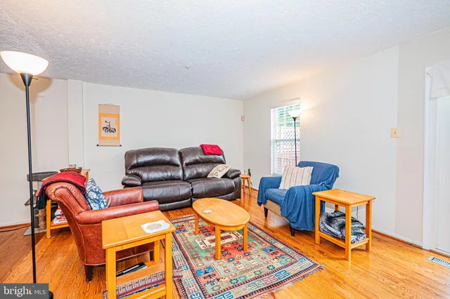 a living room with furniture a rug and a lamp