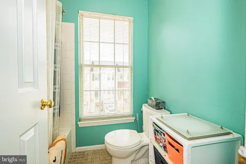 a bathroom with a toilet a sink and a window