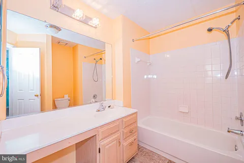 a bathroom with a granite countertop sink a mirror and a bathtub