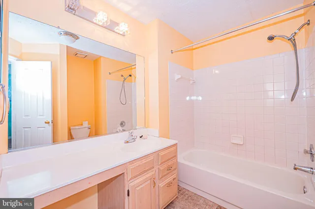 a bathroom with a granite countertop sink a mirror and a bathtub