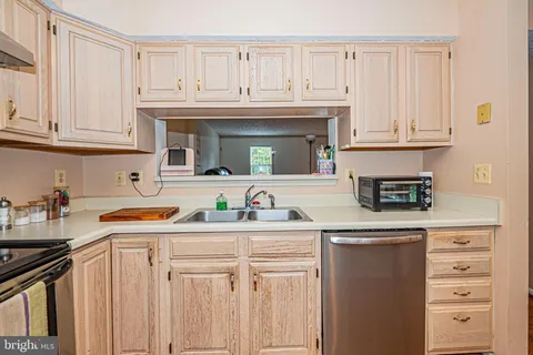a kitchen with stainless steel appliances granite countertop a sink and dishwasher a stove with wooden cabinets