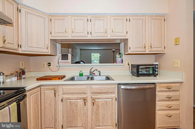 a kitchen with stainless steel appliances granite countertop a sink and dishwasher a stove with wooden cabinets