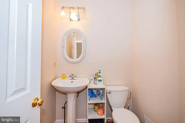 a bathroom with a toilet sink and mirror