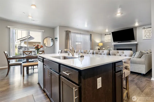 a kitchen with a sink and a stove top oven with wooden floor