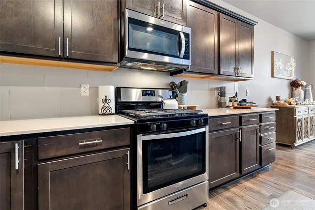 a kitchen with stainless steel appliances a stove a microwave sink and cabinets