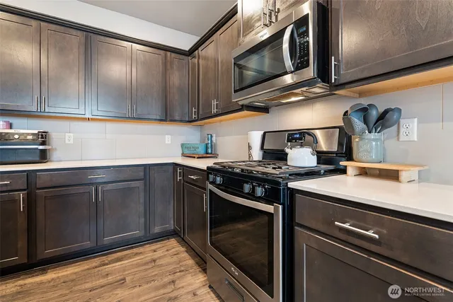 a kitchen with stainless steel appliances granite countertop a sink and a stove