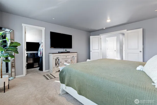 a bedroom with a bed and a flat screen tv