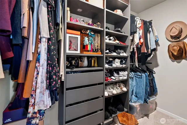 a view of walk in closet with clothes and shoes