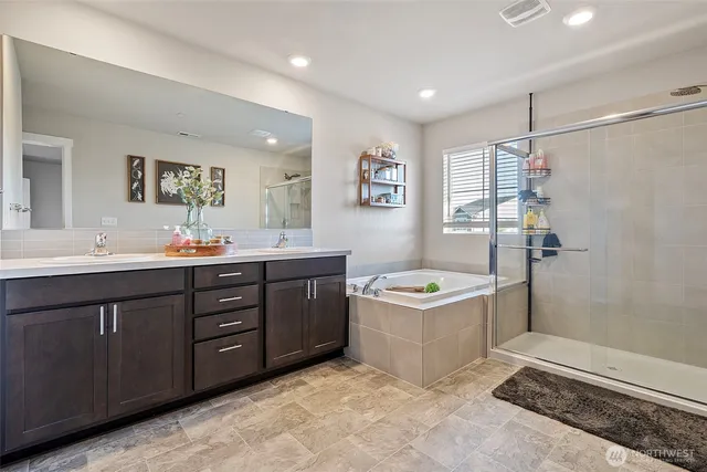 a bathroom with a tub a sink and mirror