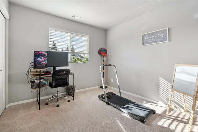 a view of a workspace with furniture and a window