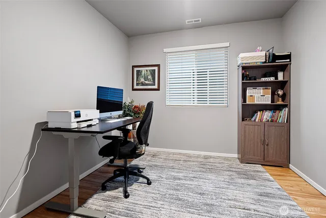 a view of a workspace with furniture and a window