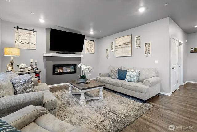 a living room with furniture a flat screen tv and a fireplace