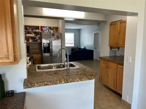 a kitchen with stainless steel appliances granite countertop a sink a refrigerator and a granite counter tops