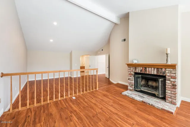 a view of dinning room with wooden floor fireplace and a window