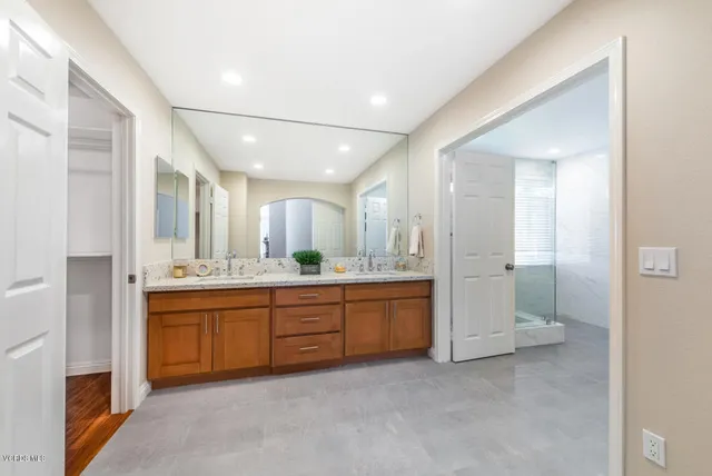 a large bathroom with a large mirror vanity and shower