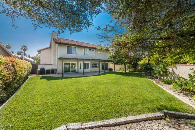 a view of a house with backyard and garden