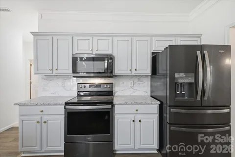a kitchen with white cabinets and stainless steel appliances